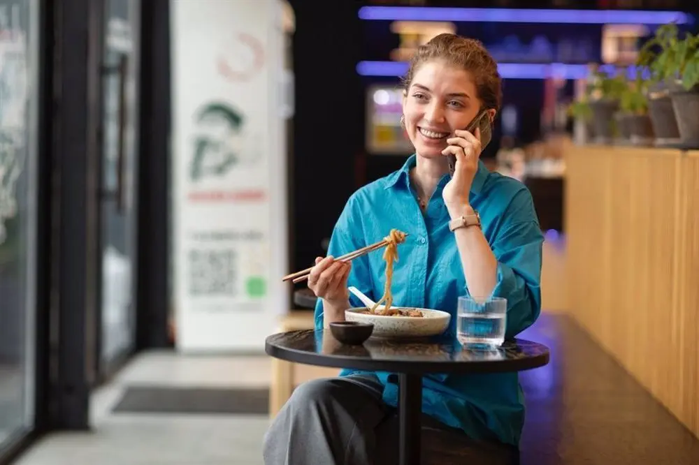 Trabajadora de la hosteler&iacute;a atendiendo por tel&eacute;fono
