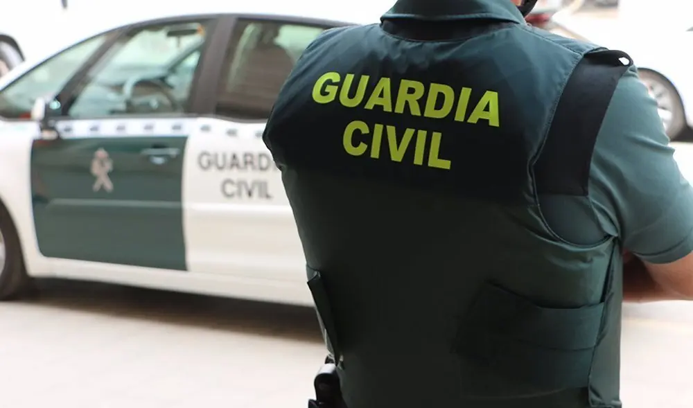 Agente de la Guardia Civil de espaldas y de brazos cruzados