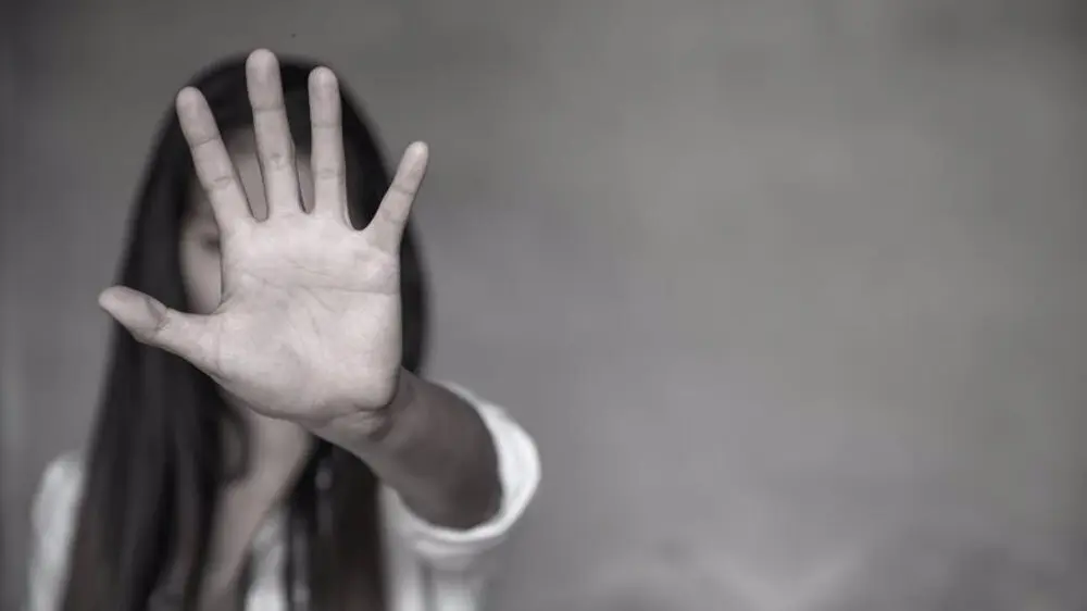 Mujer cubriendo con su mano expandida el objetivo de la c&aacute;mara