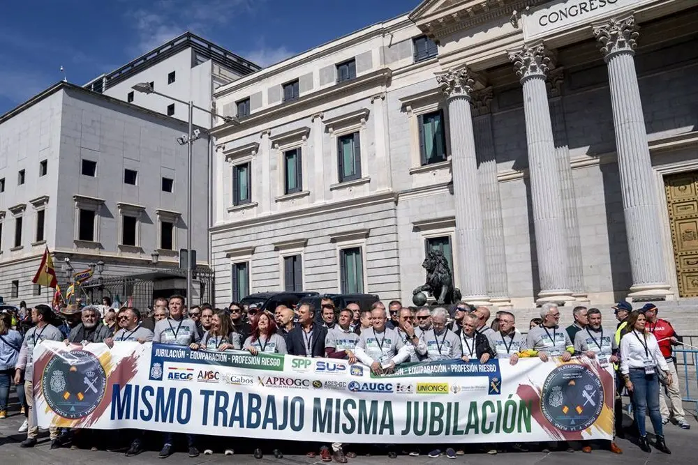 Cartel en una manifestaci&oacute;n frente al Congreso de los Diputados en el que aparece escrito "Mismo trabajo, misma jubilaci&oacute;n"