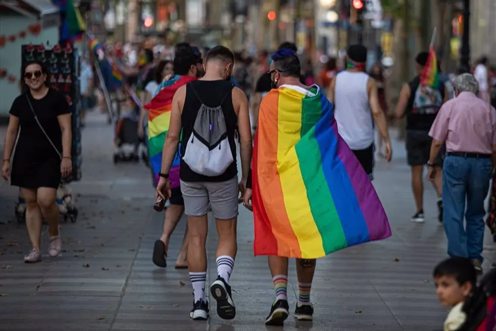 Personas paseando por Madrid con banderas del colectivo LGTBI