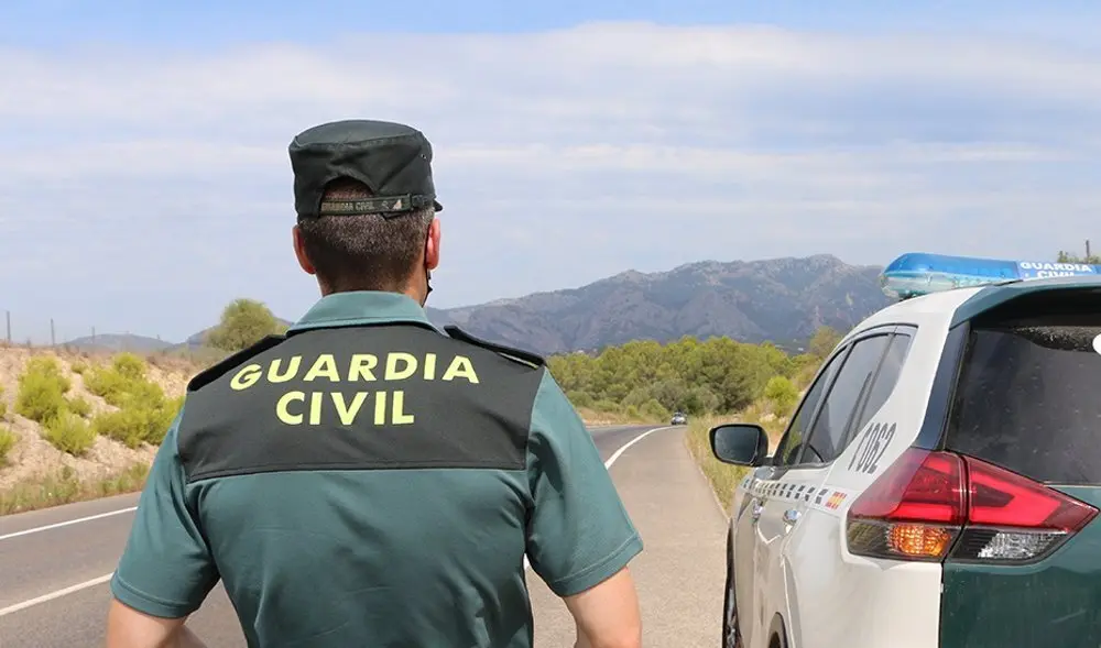 Agente de la Guardia Civil junto a su veh&iacute;culo