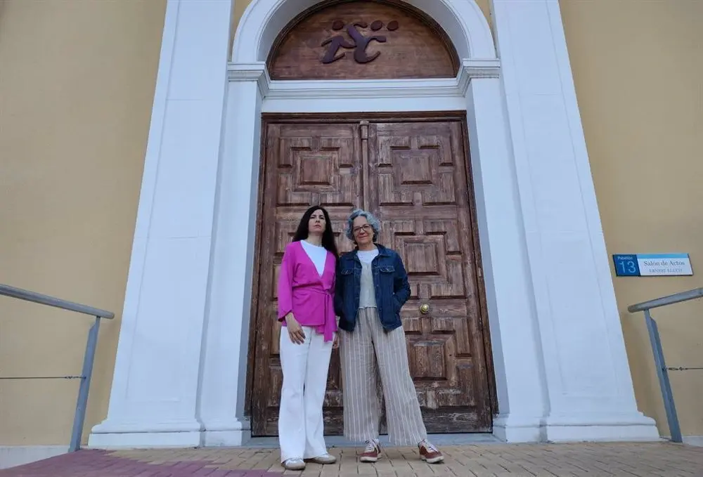 Dos mujeres frente a una puerta de entrada grande