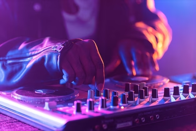 Persona juganco con una mesa de mezclas de DJ