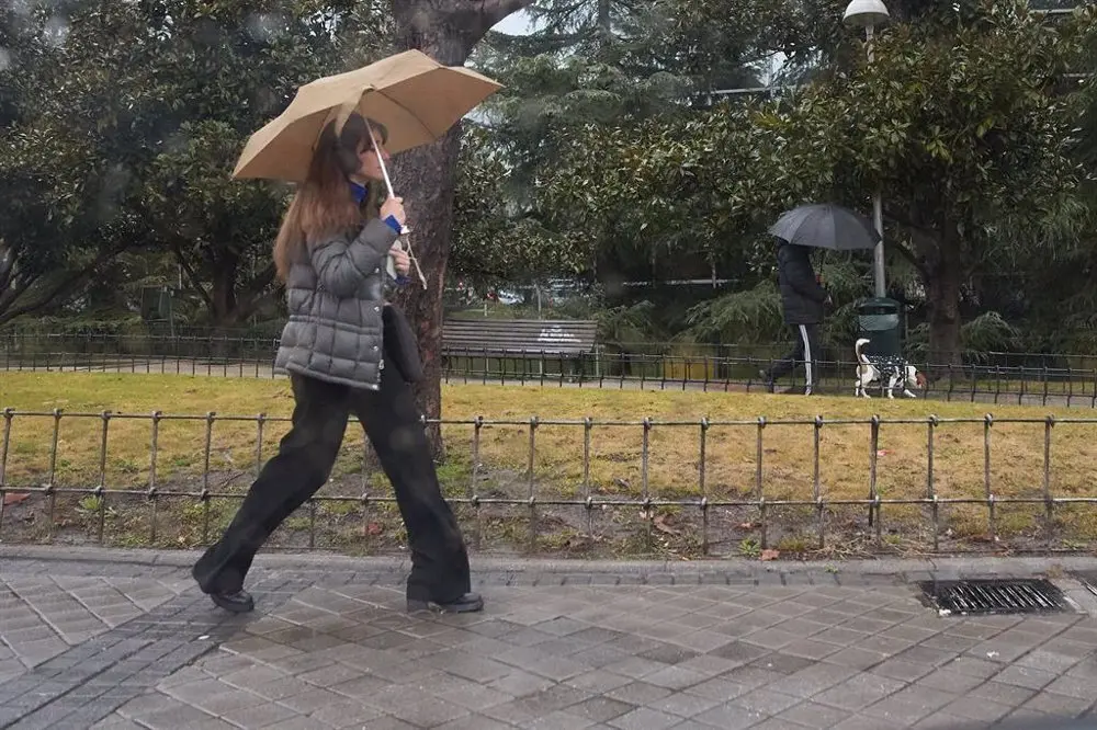 Se&ntilde;ora sosteniendo un paraguas abierto sobre su cabeza