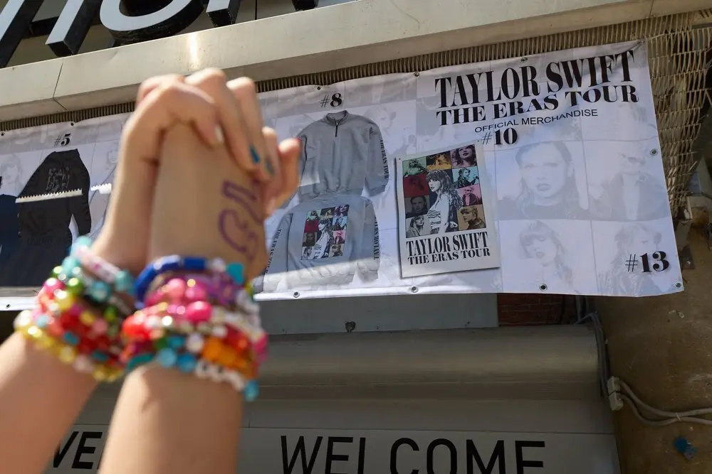 Dos manos entrelazadas frente al puesto de merchandising del concierto de Taylor Swift en Madrid