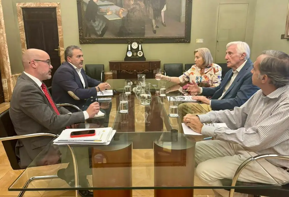 Personas reunidas alrededor de una mesa cuadrada