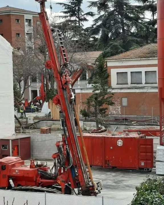 Obras y maquina excavadora roja
