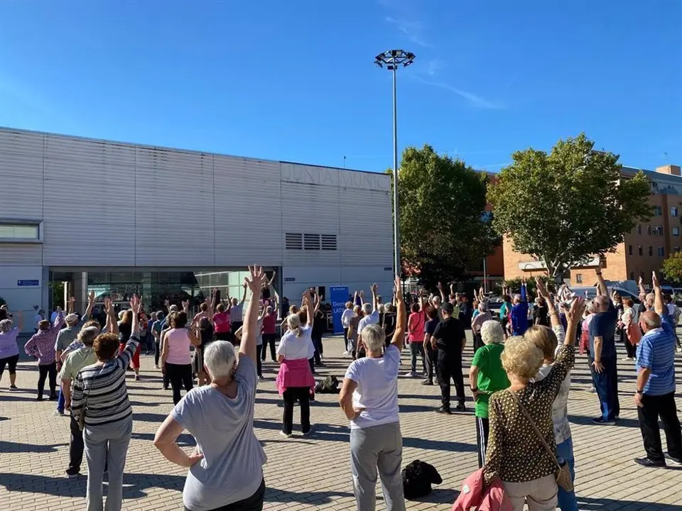 Un grupo de personas mayores bailando en una masterclass de zumba al aire libre 