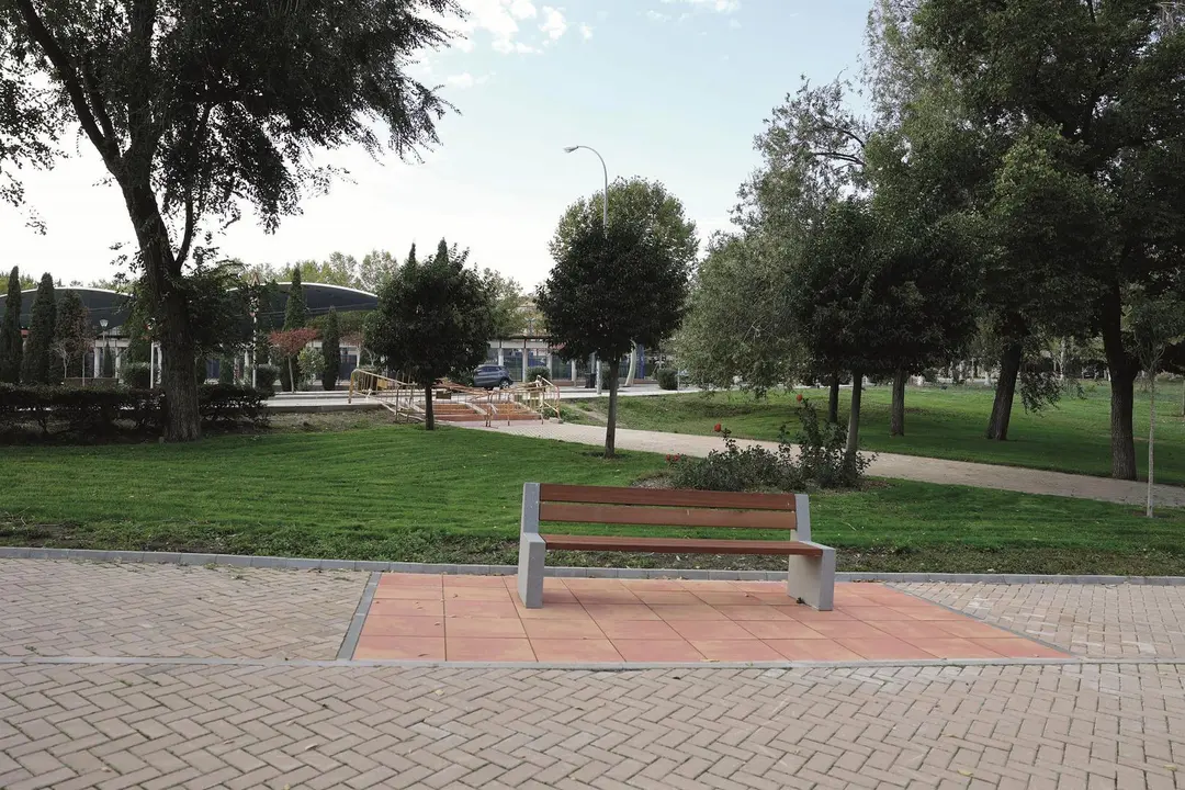 Imagen de uno de los parques de Pozuelo de Alarc&oacute;n donde aparece un banco rodeado de zonas verdes