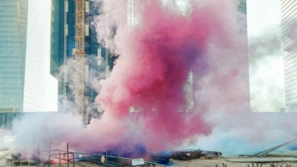 Una nube de humo rosa frente a las Cuatro Torres de Madrid