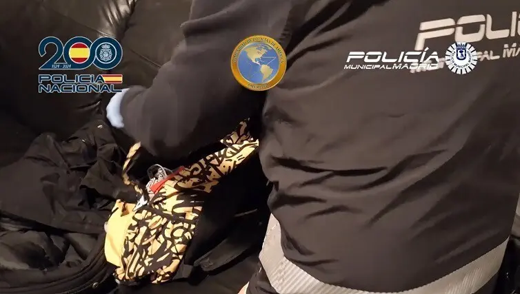 Agente de la Polic&iacute;a Nacional de Madrid registrando una mochila.