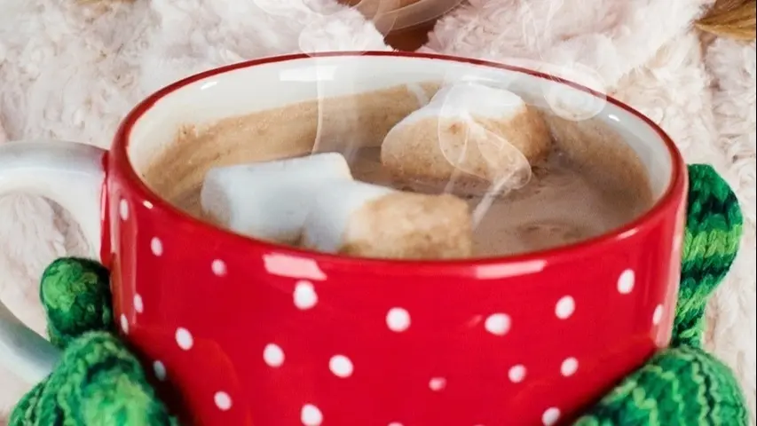 Taza de chocolate con nubes flotando.