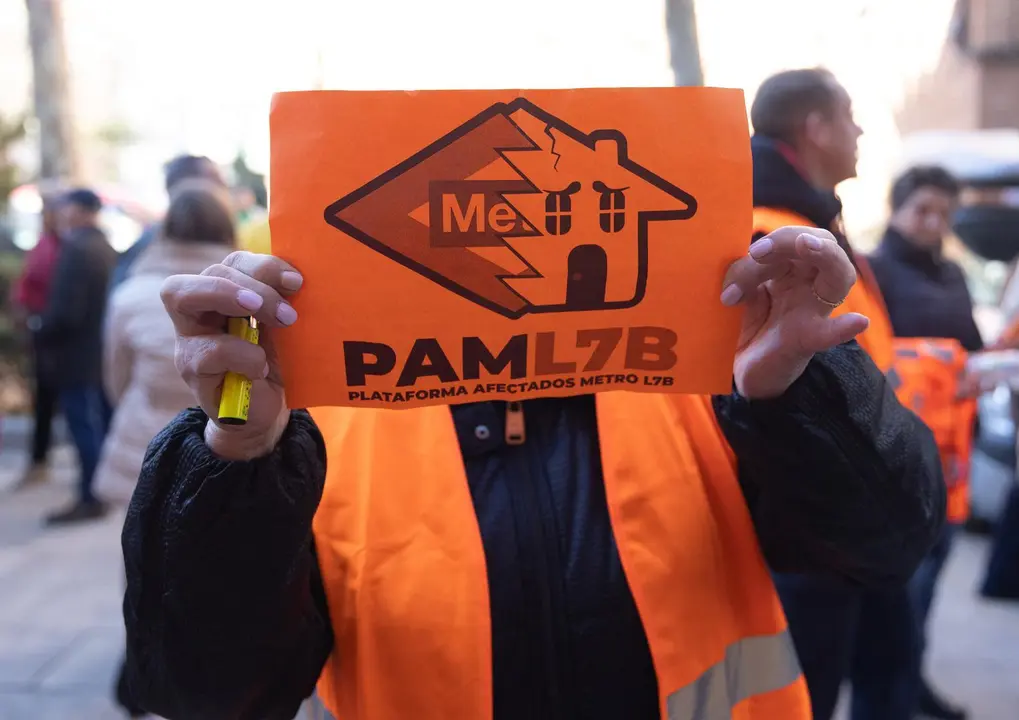 Una mujer porta una pancarta de la Plataforma de Afectados Metro L7B.
