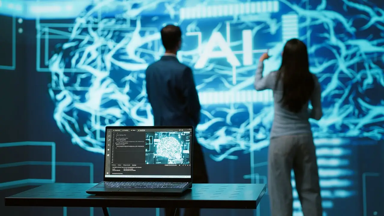 Imagen de archivo. La Inteligencia artificial gestionada por un hombre y una mujer de espaldas.