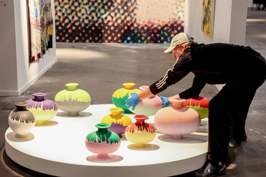 Una persona coloca un jarr&oacute;n dentro de una galer&iacute;a un d&iacute;a antes de la inauguraci&oacute;n de ARCO 2023.