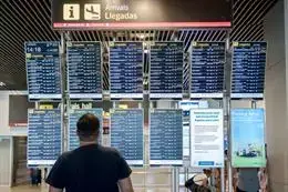 Un hombre observa el panel de llegadas de vuelos en la terminal 1 del aeropuerto Adolfo Su&aacute;rez Madrid-Barajas