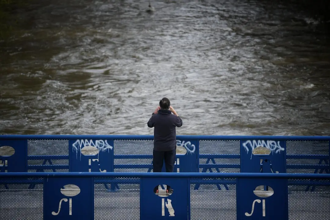 Una persona fotograf&iacute;a la crecida del r&iacute;o, en el parque lineal del Manzanares, a 20 de marzo de 2025, en Madrid (Espa&ntilde;a).