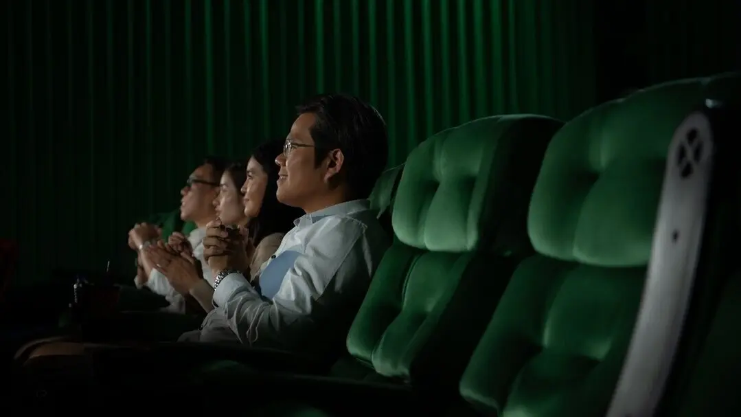 Familia disfrutando de una pel&iacute;cula en el cine. Imagen de archivo.