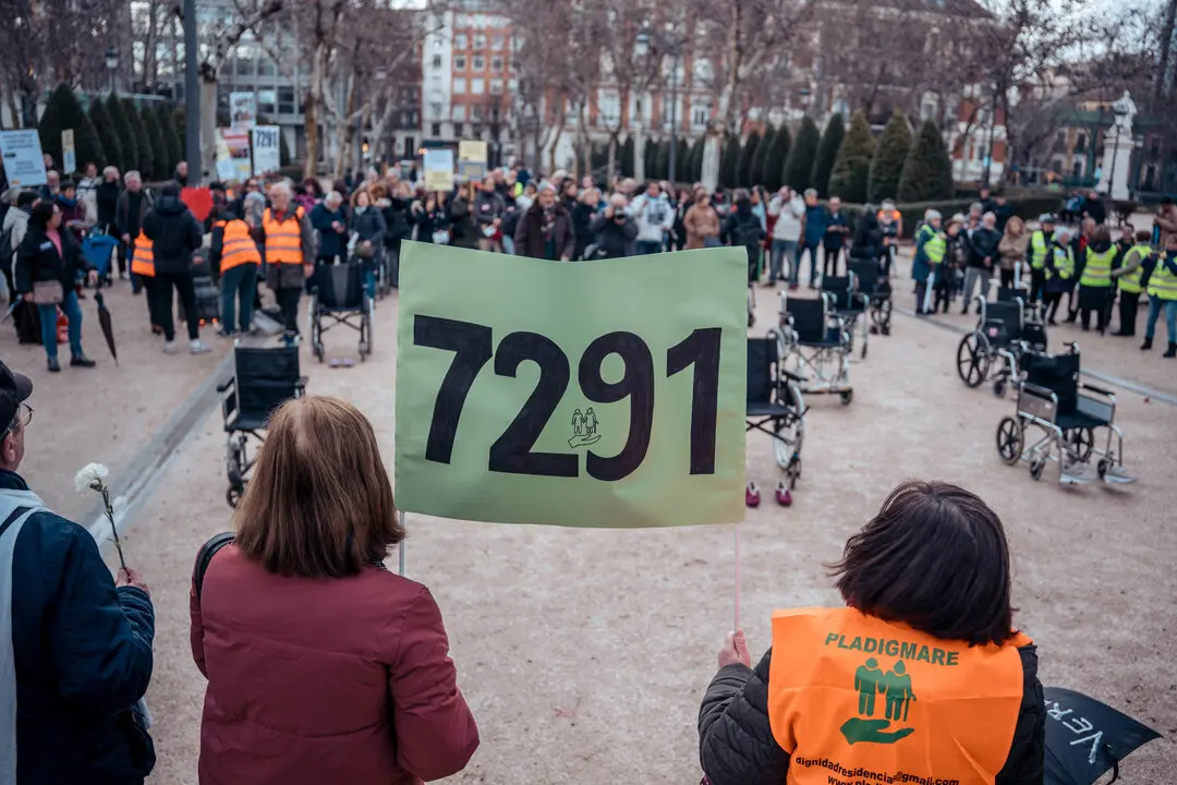 Varias personas sostienen una pancarta durante una concentraci&oacute;n de asociaciones y sindicatos en recuerdo a las 7.291 v&iacute;ctimas en las residencias de mayores durante la pandemia de covid-19, en la plaza Villa de Par&iacute;s, Madrid, a 18 de marzo de 2025.