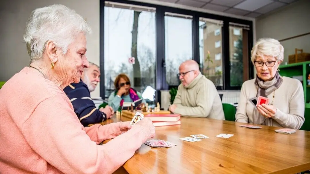 Personas mayores jugando una partida de cartas. Imagen de archivo.