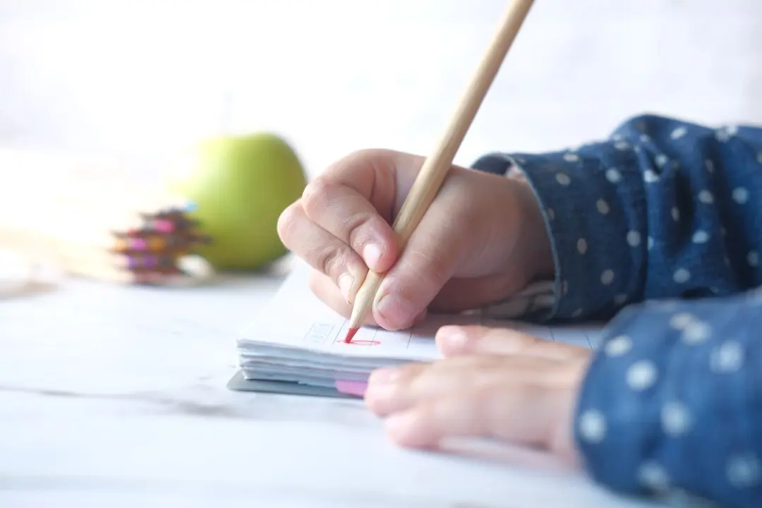 Un ni&ntilde;o o ni&ntilde;a escribiendo. Imagen de archivo.