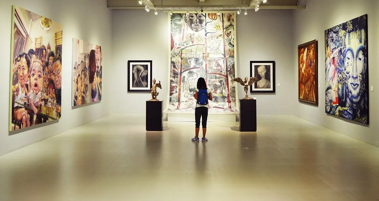 Una mujer mirando una obra de arte en un museo en imagen de archivo.