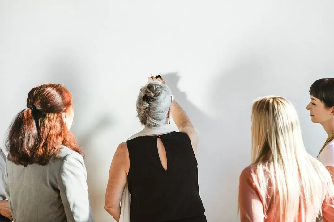 Mujeres escribiendo en una pared. Imagen de archivo.