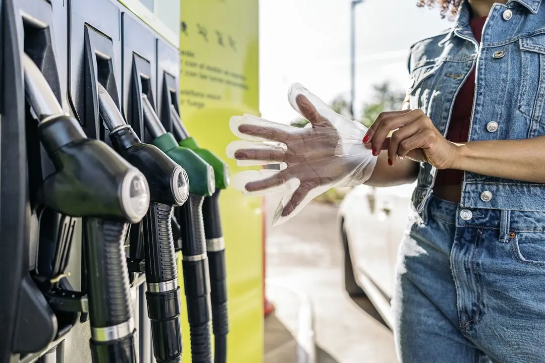 Una persona repostando en una gasolinera. Imagen de archivo.