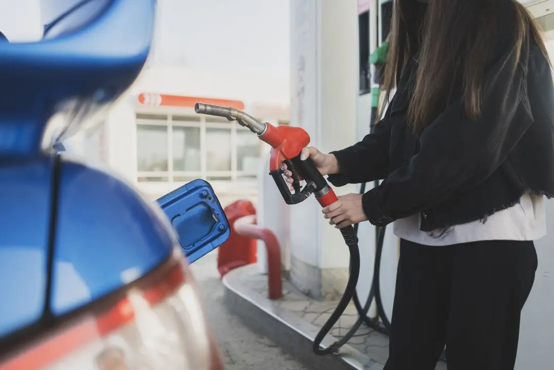Una persona repostando en una gasolinera. Imagen de archivo.