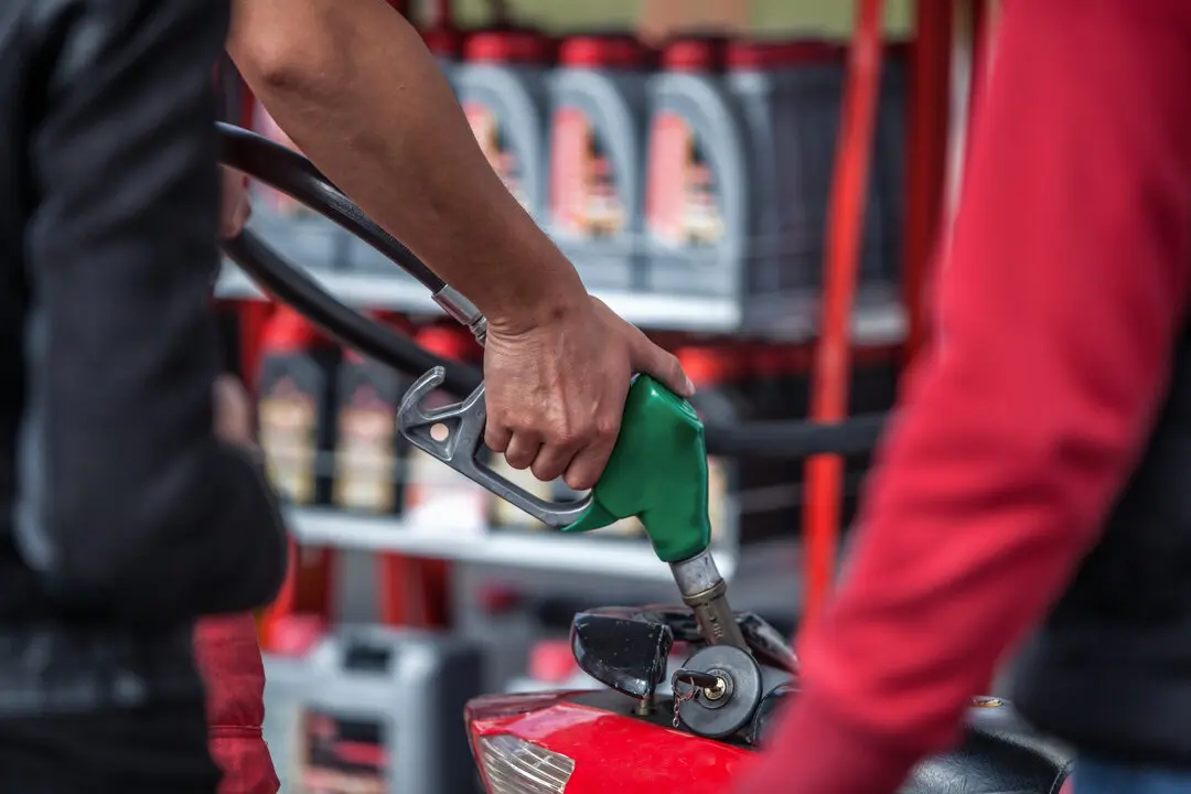 Una persona repostando en una gasolinera. Imagen de archivo.