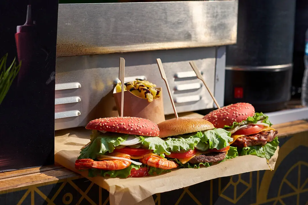 Tres hamburguesas en un food truck. Imagen de archivo.