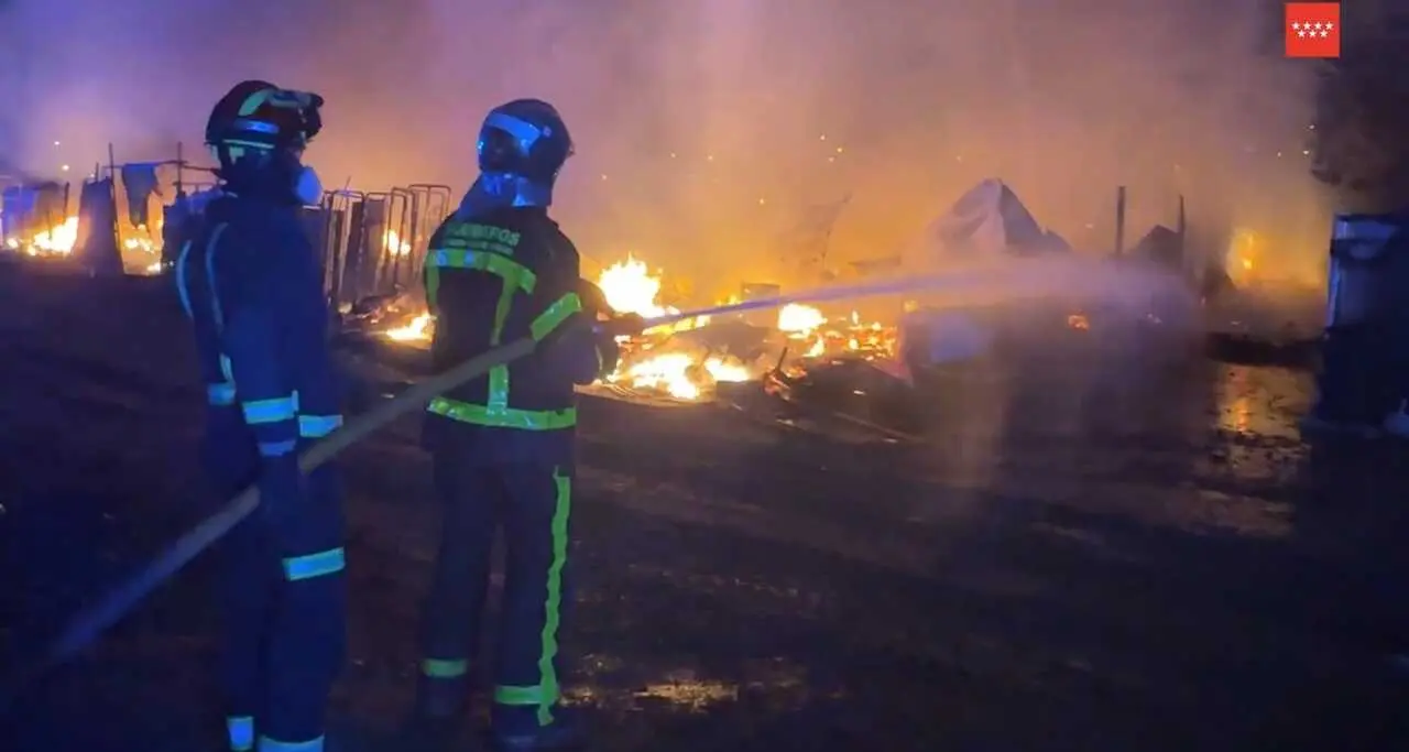 Dos bomberos de la Comunidad de Madrid tratan de apagar un incendio en infraviviendas en Legan&eacute;s Norte. Imagen de 112 Comunidad de Madrid.