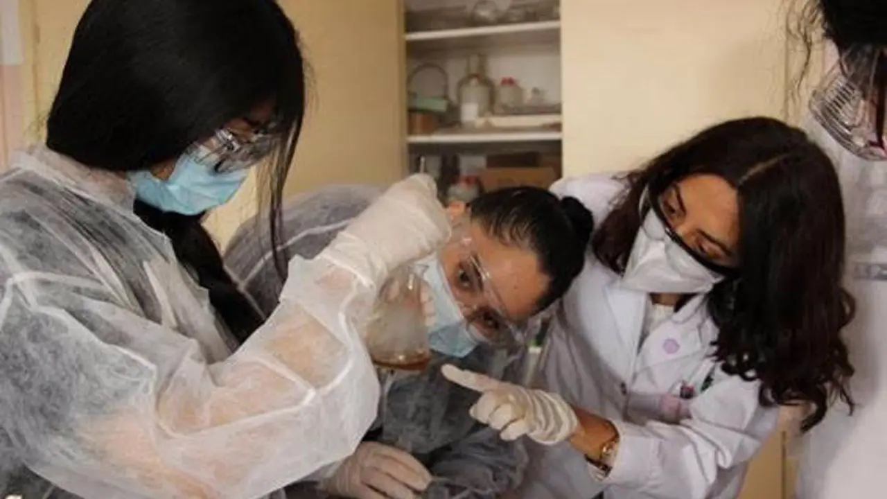 Mujeres cient&iacute;ficas en medio de un experimento.
