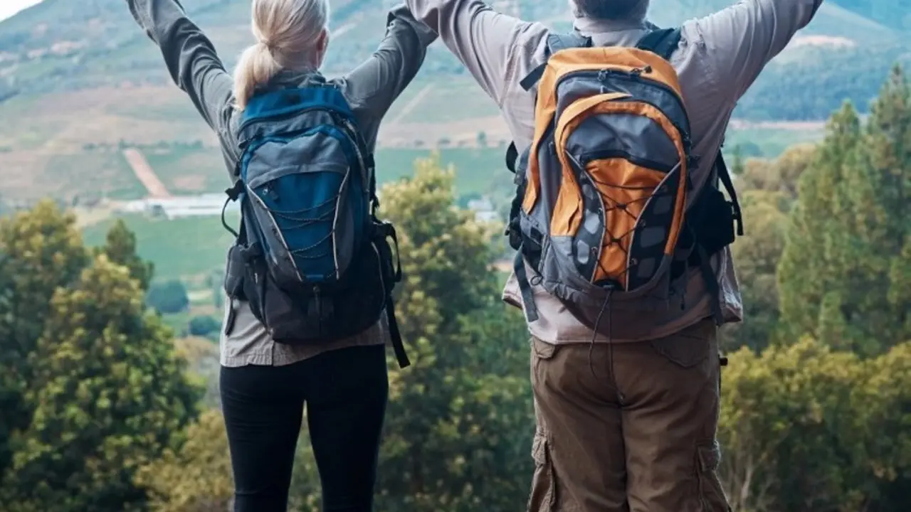 Se&ntilde;ores mayores con las manos levantadas en lo alto de una monta&ntilde;a.