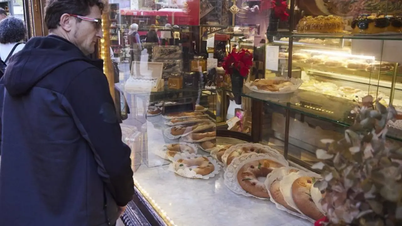 Se&ntilde;or mirando a trav&eacute;s del escaparate de una pasteler&iacute;a artesanal