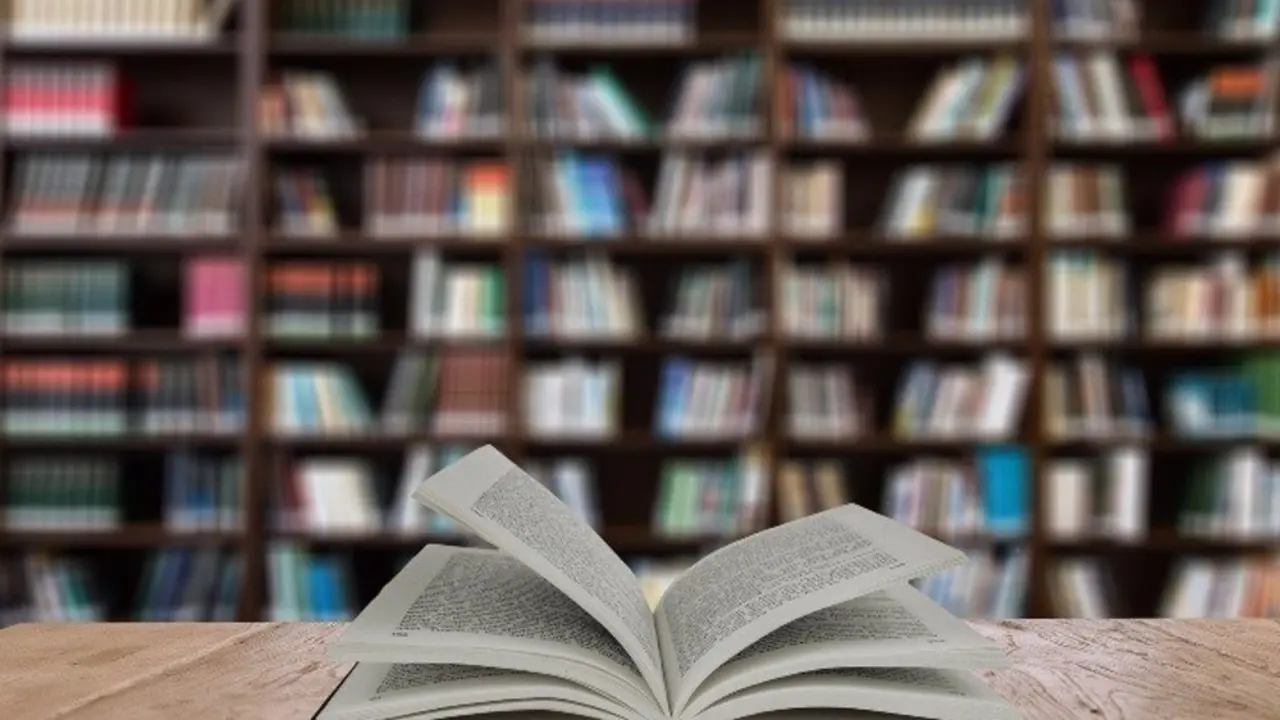 Libro abierto sobre la mesa de una biblioteca.