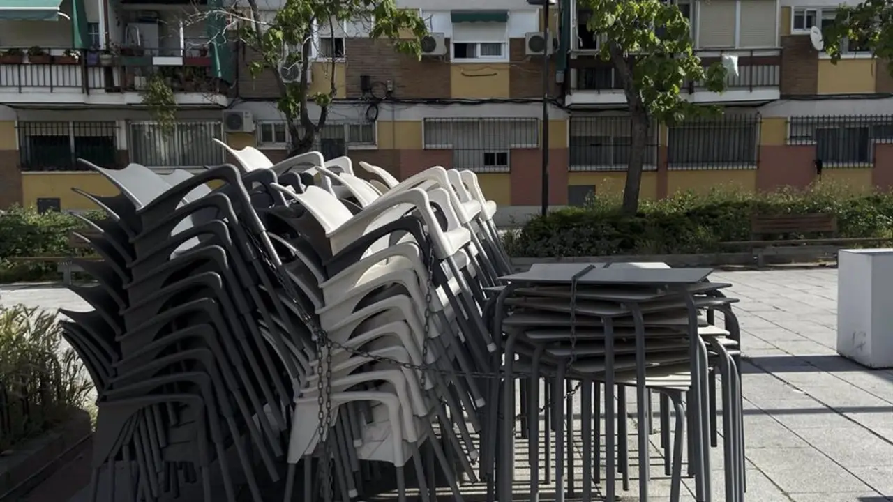 Sillas y mesas apiladas en la terraza de un bar