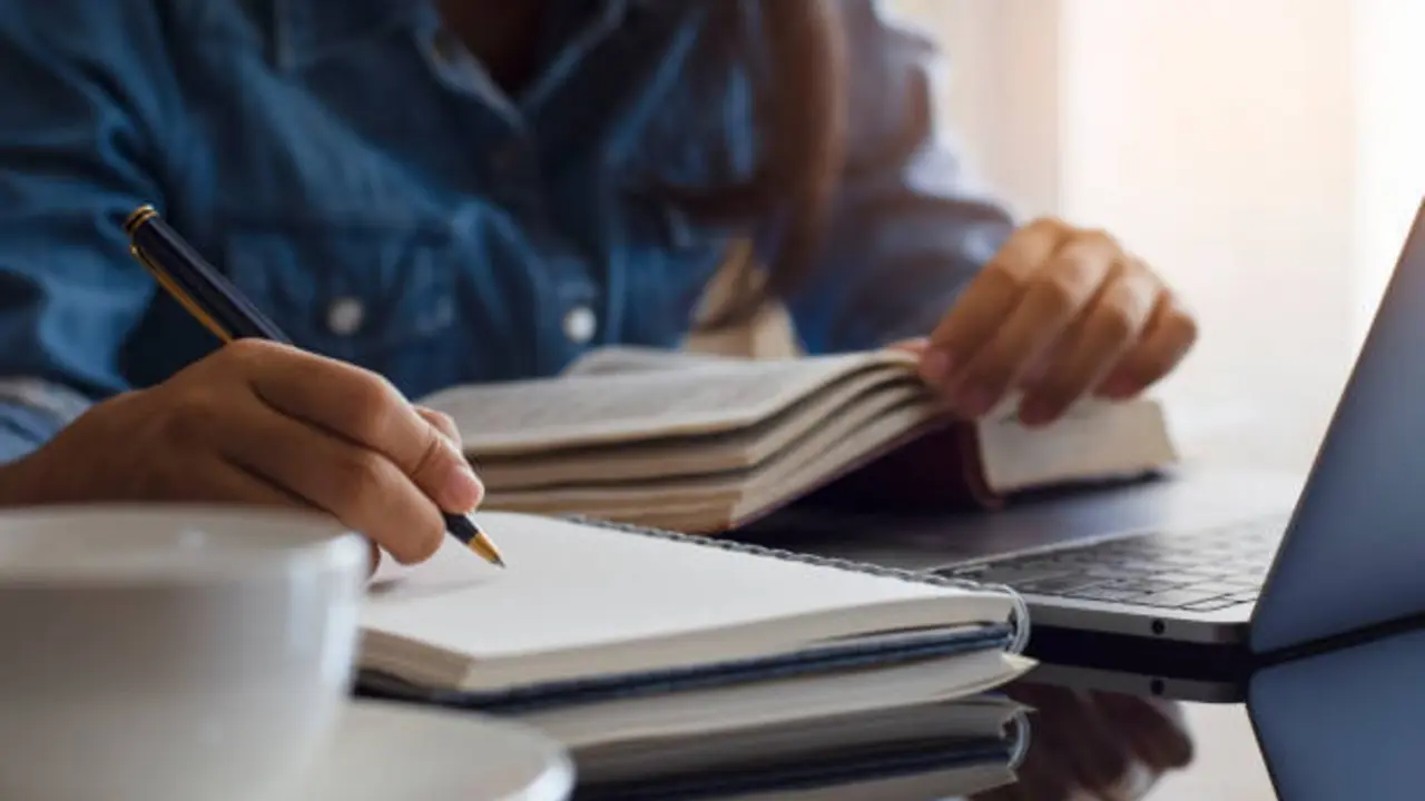 Persona estudiando y anotando en su libreta