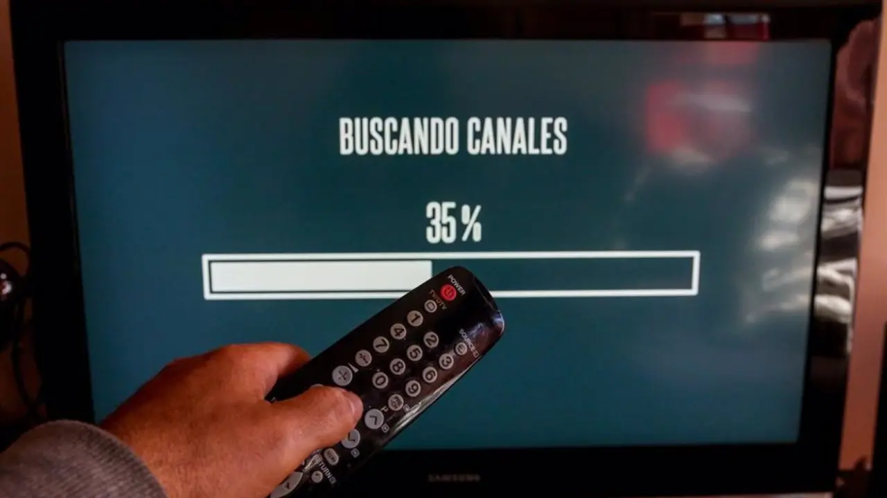 Persona resintonizando canales en su televisor