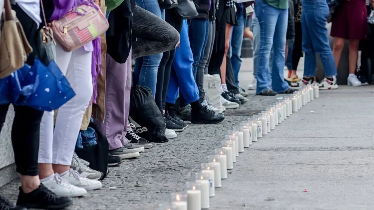 Camino de velas y personas situadas en frente del camino