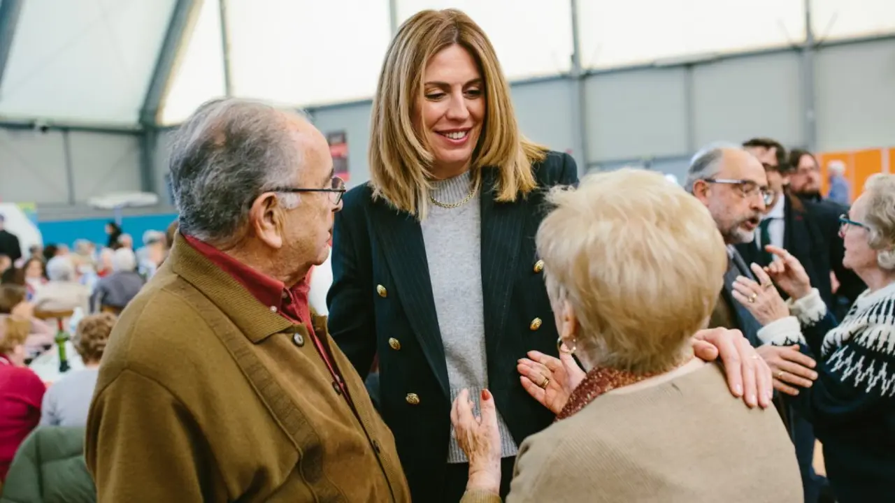Mujer adulta sonriendo a dos personas mayores