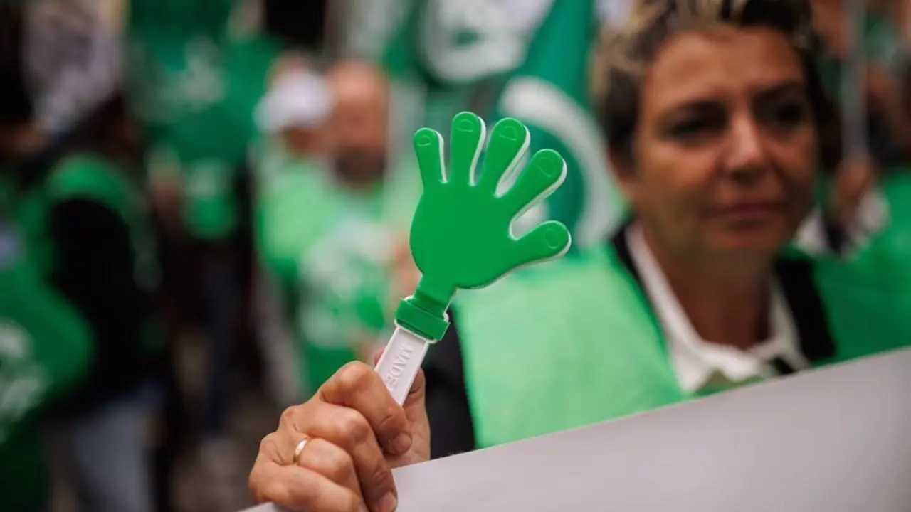 Mujer sosteniendo un palo con una mano dibujada de color verde
