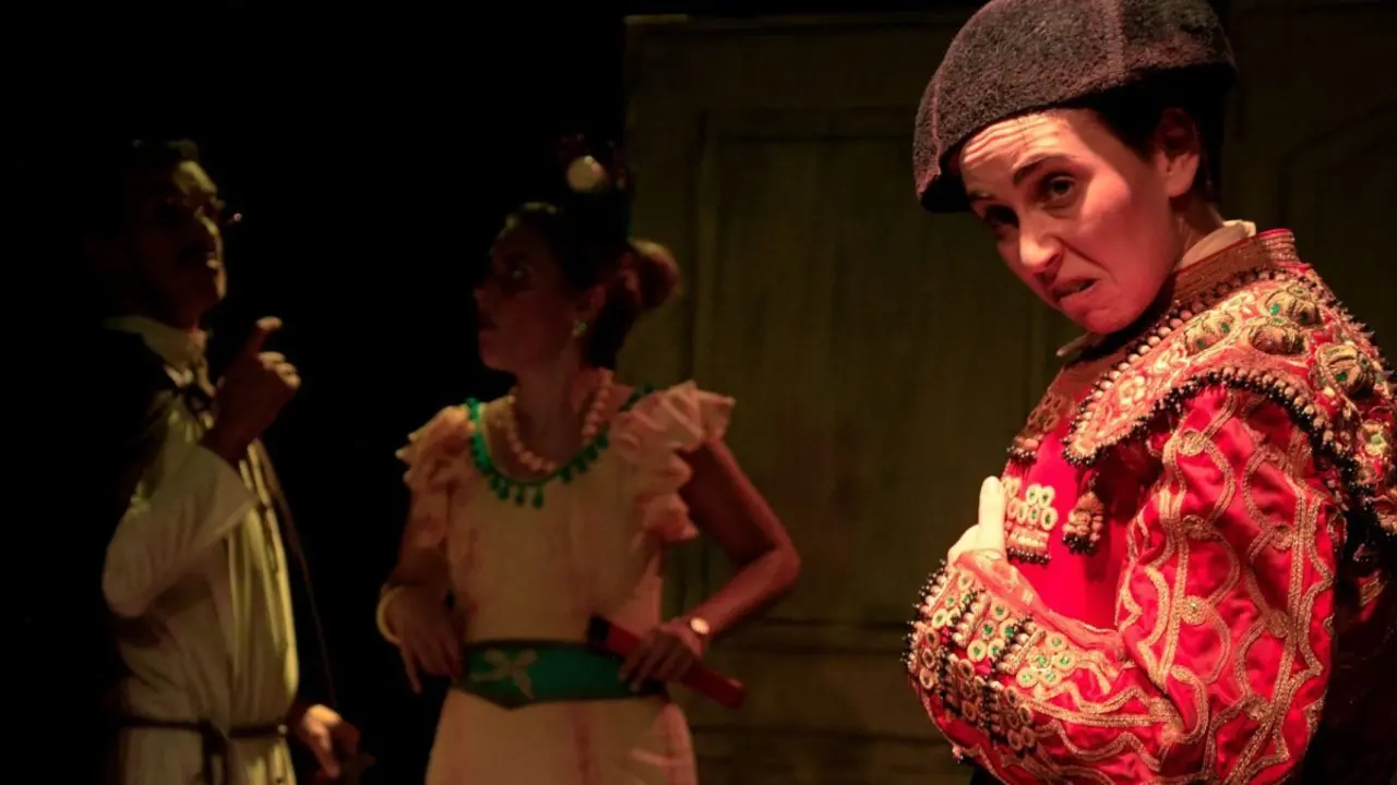 Una mujer con tres mujeres de fondo en un Teatro. 