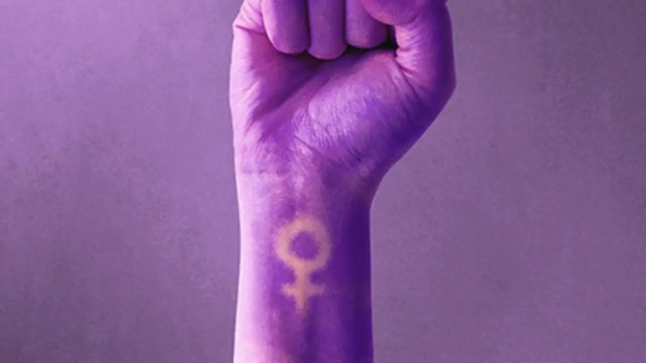 Pu&ntilde;o cerrado pintado de morado con el s&iacute;mbolo de la mujer por el 8M.