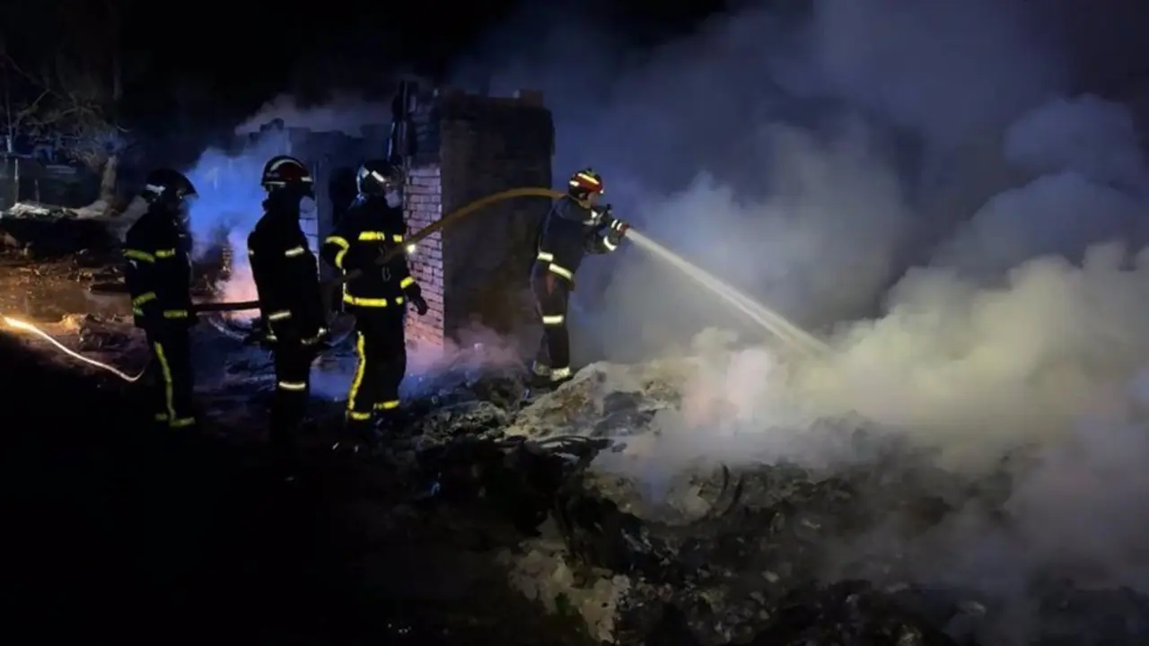 Bomberos apagando un incendio de noche