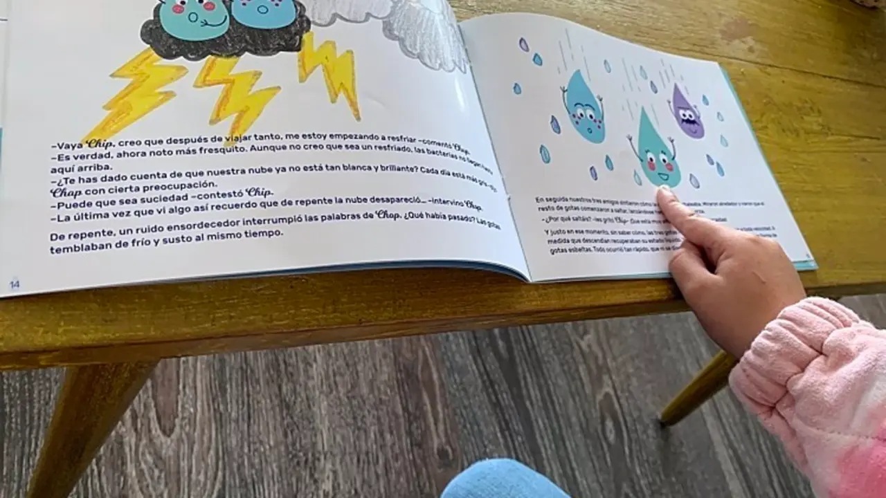 Ni&ntilde;a peque&ntilde;a se&ntilde;alando un dibujo de una hoja de un libro
