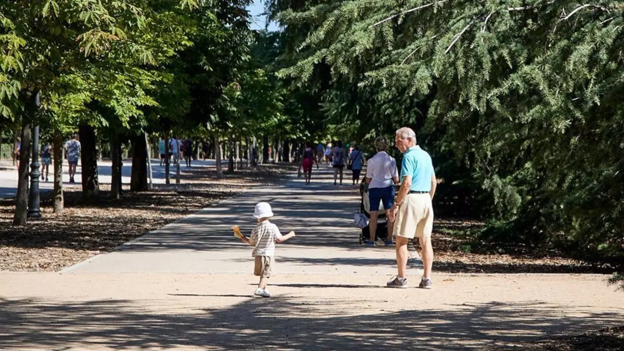 Se&ntilde;or mayor con una ni&ntilde;a peque&ntilde;a paseando por El Retiro de Madrid