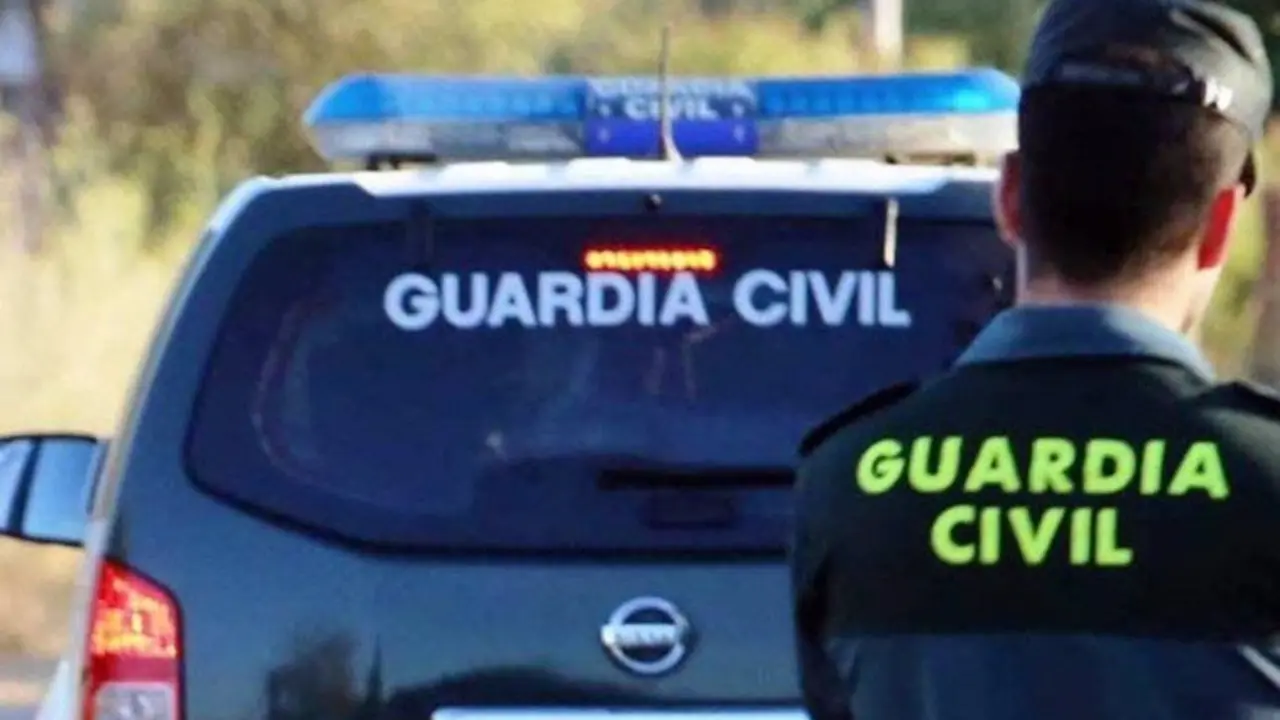Veh&iacute;culo de la Guardia Civil con un agente de la Guardia Civil en frente