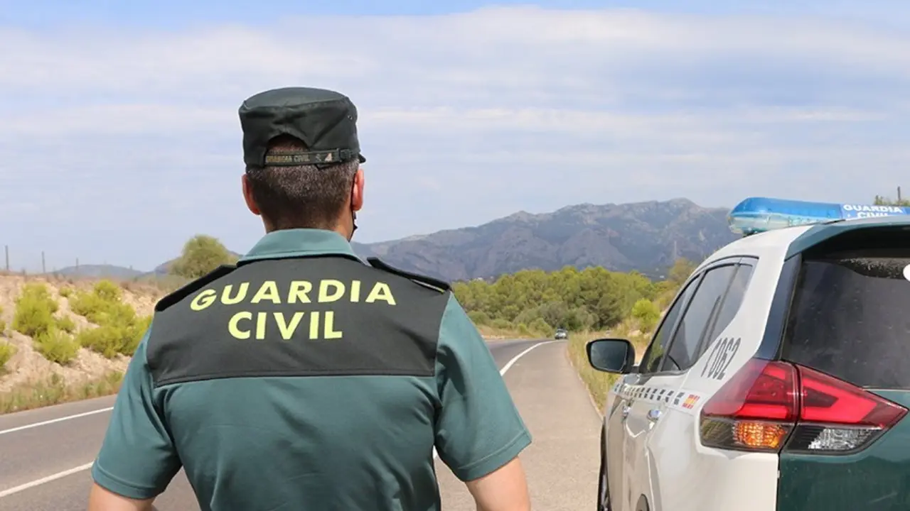Agente de la Guardia Civil junto a su veh&iacute;culo